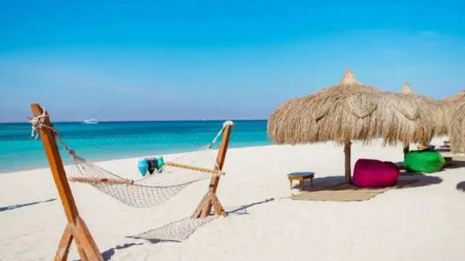Hammock and thatched umbrellas on the white sand of Hula Hula Island, Hurghada