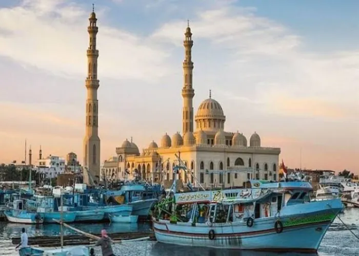 El Mina Mosque minarets rising over fishing boats in Hurghada harbour at sunset