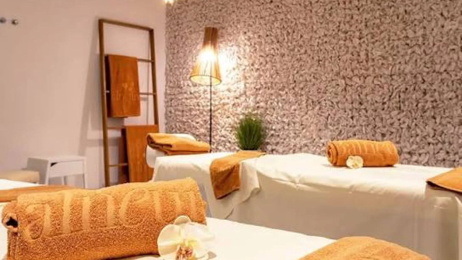 Massage beds with orange towels and orchid flowers in the spa treatment room, Hurghada