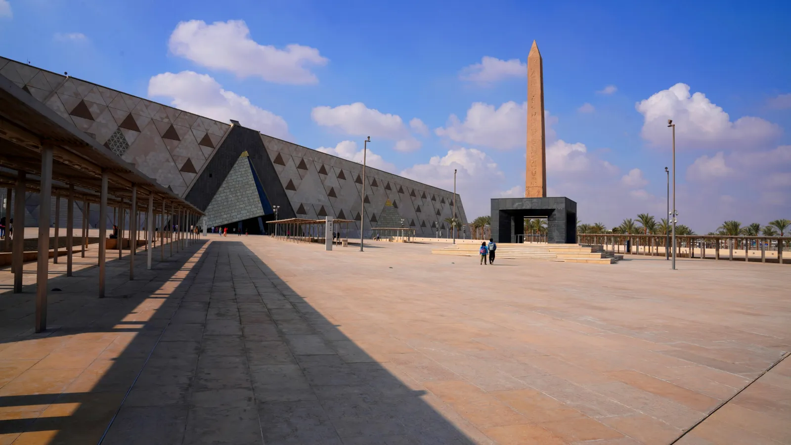 Entrance plaza and obelisk of the Grand Egyptian Museum near the Giza pyramids