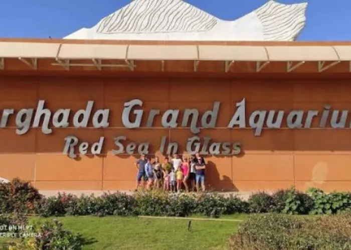 Family at the entrance sign of the Hurghada Grand Aquarium