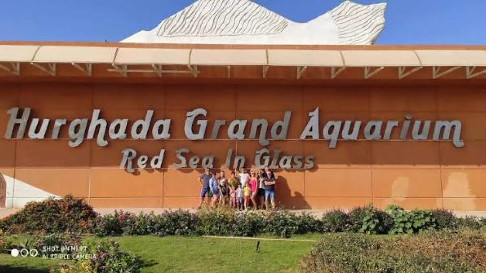 Family at the entrance sign of the Hurghada Grand Aquarium