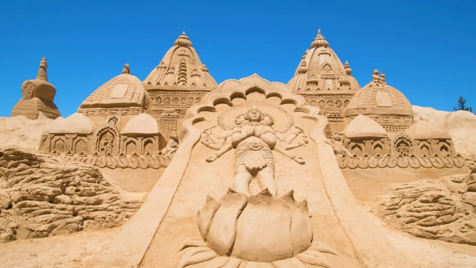 Sand-carved temple towers and a lotus figure at the Sand City open-air museum, Hurghada